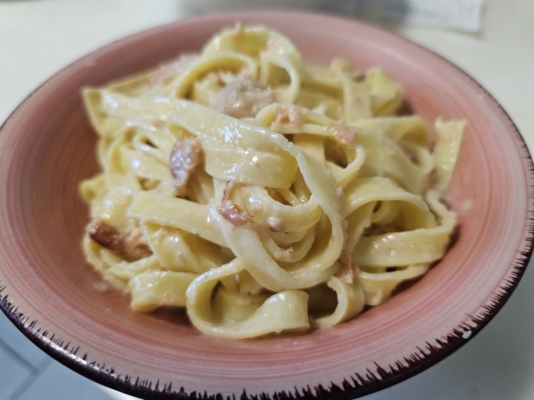 Piatto di tagliatelle fatte in casa con sugo alla panna e pancetta
